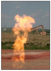 A flare burning natural gas glimmers in front of a pumping unit north of New Town.