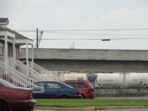 Photo: Front porches in Mobile's Orange Grove Homes housing development, with trains in the background. (Photo credit Karen Savage)
